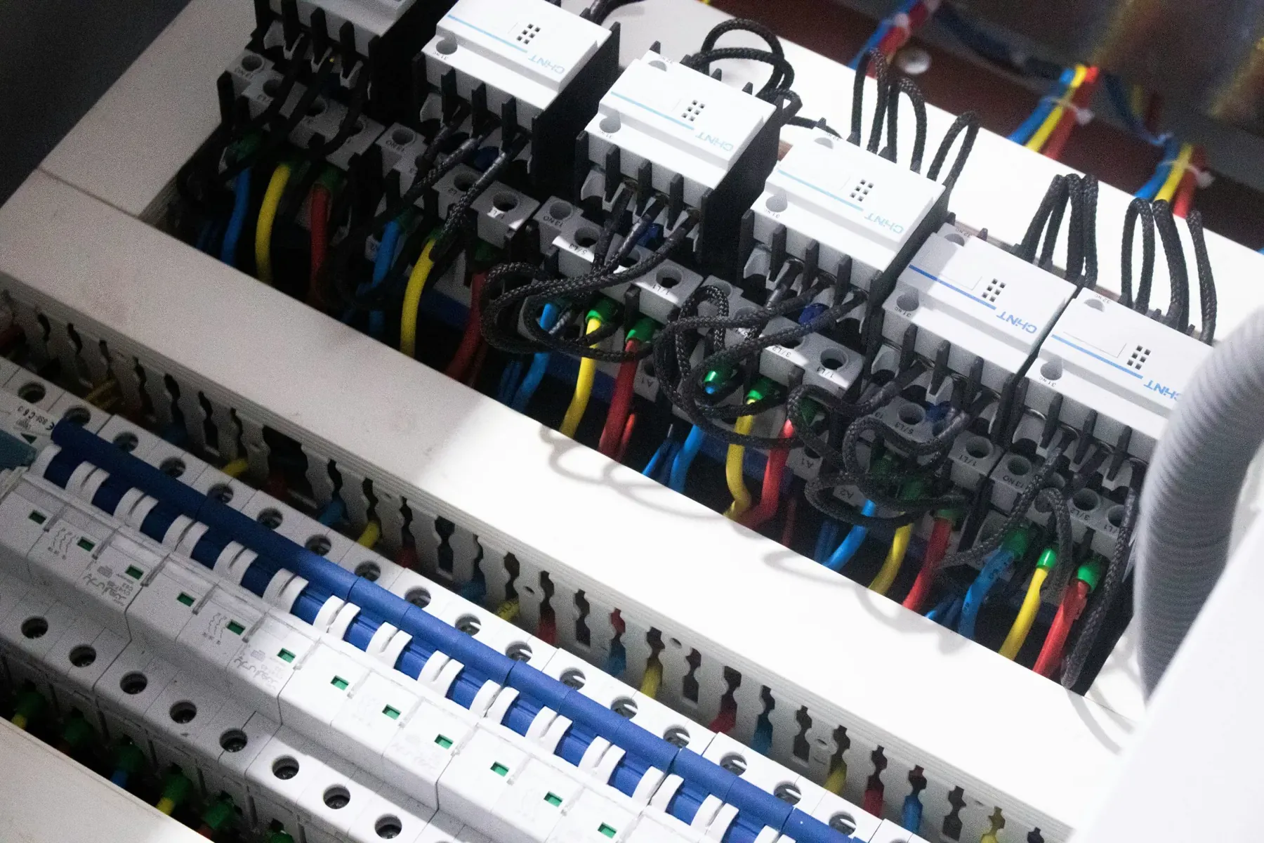 A commercial DIN-rail distribution panel with breakers and contactors wired in