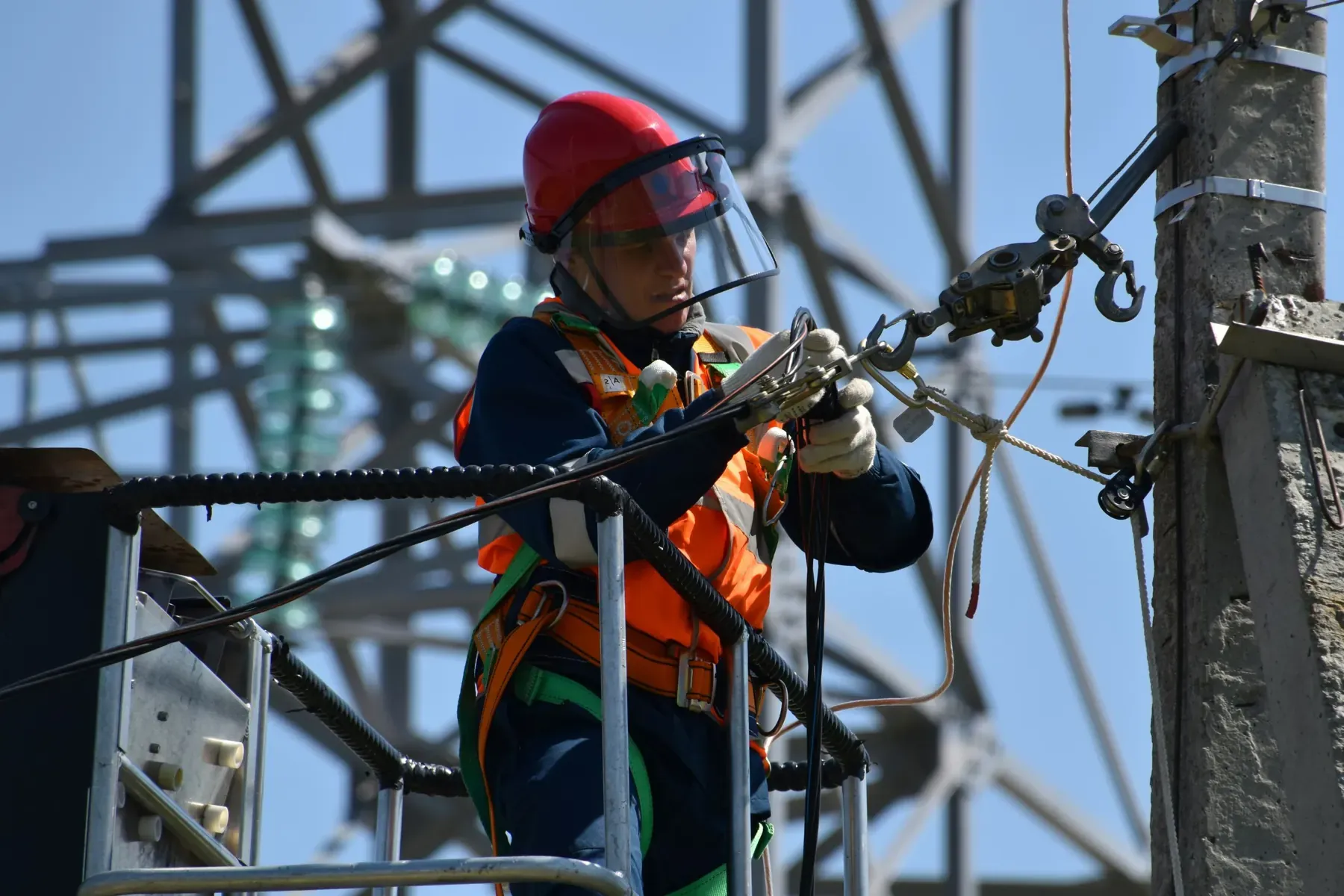 A utility lineworker in a bucket truck working on overhead power lines